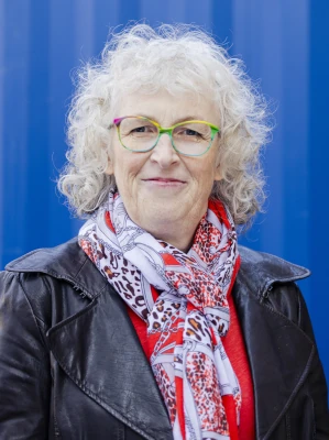 Martina Kreutz mit schwarzer Lederjacke vor blauem Hintergrund